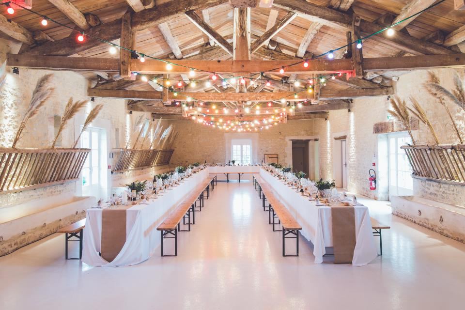 Warm string lighting above long banquet tables